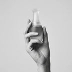 Less Face Oil Flakon in einer Hand